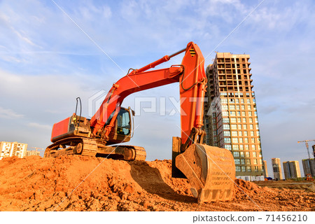 Excavator during excavation at construction site on sunset background. Excavator during excavation at construction site on sunset background. 71456210