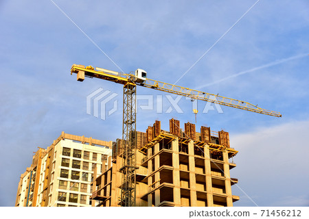Tower cranes working at construction site on on sunset background.  71456212
