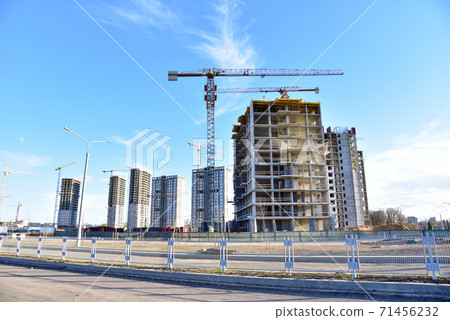 Tower cranes working at construction site on blue sky background.  71456232