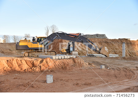 Excavator during excavation at construction site. Excavator during excavation at construction site. 71456273