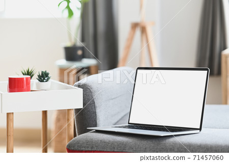 Mockup blank screen laptop on couch in living room. For graphic display montage. 71457060