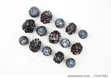 blueberries and blackberries sprinkled with coconut on white background 71457061