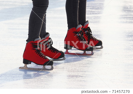 feet in red skates on an ice rink 71457270