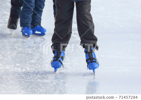 legs of a man skating on an ice rink. Sport and entertainment. Rest and winter holidays 71457284