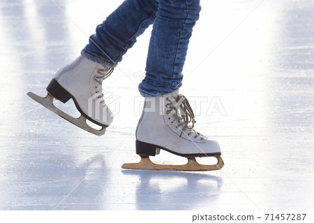 Female legs in skates on an ice rink 71457287