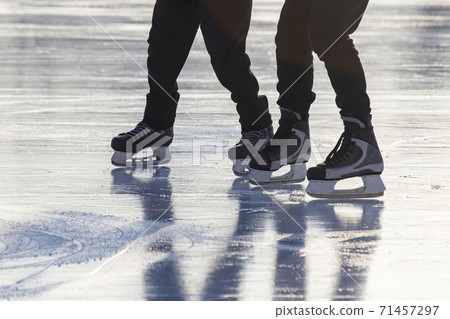 Legs of a man skating on an ice rink. Hobbies and sports. Vacations and winter activities Legs of a man skating on an ice rink. Hobbies and sports. Vacations and winter activities 71457297
