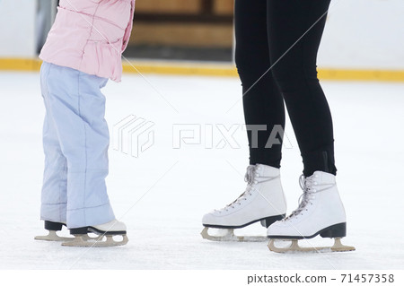 the legs of a man skating on an ice rink the legs of a man skating on an ice rink 71457358