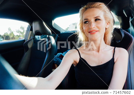 Beautiful blonde woman behind the wheel of car rides 71457602