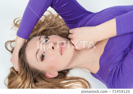 Beautiful woman in purple leggings and top posing on a white background Beautiful woman in purple leggings and top posing on a white background 71459120