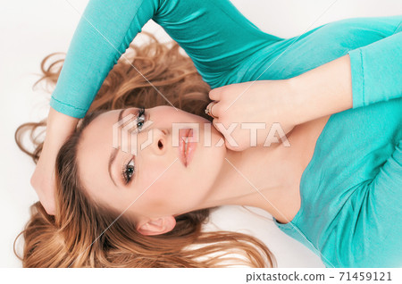 Beautiful woman in azure leggings and top posing on a white background Beautiful woman in azure leggings and top posing on a white background 71459121