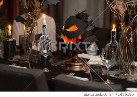Table set for Halloween dinner. Served holiday table with candles and pumpkin 71459190