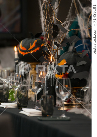Table set for Halloween dinner. Served holiday table with candles and pumpkin Table set for Halloween dinner. Served holiday table with candles and pumpkin 71459191