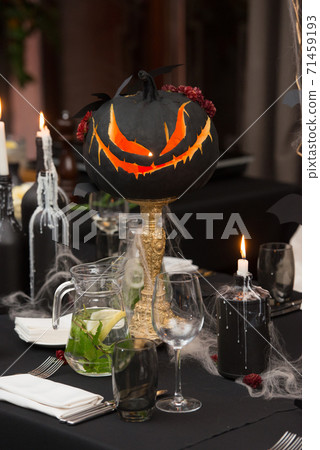 Table set for Halloween dinner. Served holiday table with candles and pumpkin 71459193