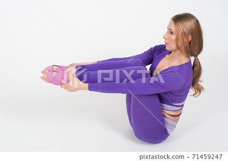 Beautiful woman in purple leggings and top doing exercise for stretching on a white background Beautiful woman in purple leggings and top doing exercise for stretching on a white background 71459247
