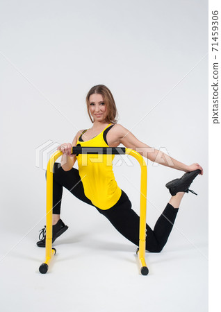 Woman doing exercises with high yellow floor bars on a white background Woman doing exercises with high yellow floor bars on a white background 71459306