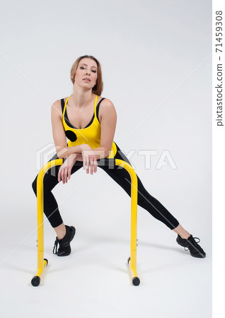Woman doing exercises with high yellow floor bars on a white background 71459308