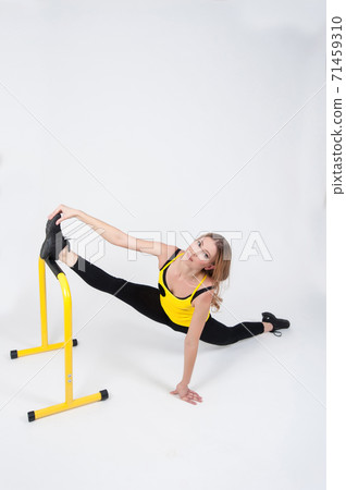 Woman doing exercises with high yellow floor bars on a white background 71459310