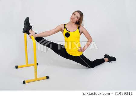 Woman doing exercises with high yellow floor bars on a white background 71459311