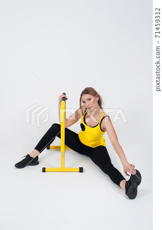 Woman doing exercises with high yellow floor bars on a white background 71459312
