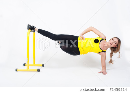 Woman doing exercises with high yellow floor bars on a white background Woman doing exercises with high yellow floor bars on a white background 71459314