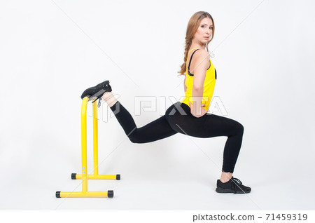 Woman doing exercises with high yellow floor bars on a white background Woman doing exercises with high yellow floor bars on a white background 71459319