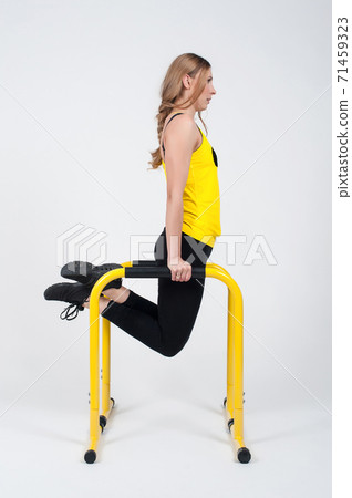 Woman doing exercises with high yellow floor bars on a white background Woman doing exercises with high yellow floor bars on a white background 71459323