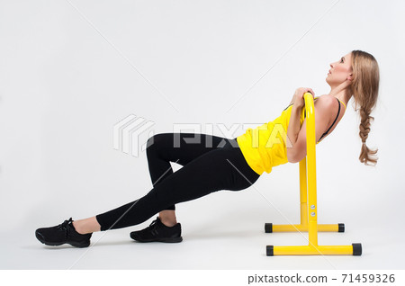 Woman doing exercises with high yellow floor bars on a white background Woman doing exercises with high yellow floor bars on a white background 71459326