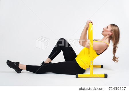 Woman doing exercises with high yellow floor bars on a white background Woman doing exercises with high yellow floor bars on a white background 71459327