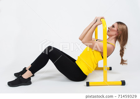 Woman doing exercises with high yellow floor bars on a white background Woman doing exercises with high yellow floor bars on a white background 71459329