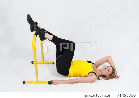 Woman doing exercises with high yellow floor bars on a white background Woman doing exercises with high yellow floor bars on a white background 71459330