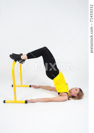 Woman doing exercises with high yellow floor bars on a white background Woman doing exercises with high yellow floor bars on a white background 71459332