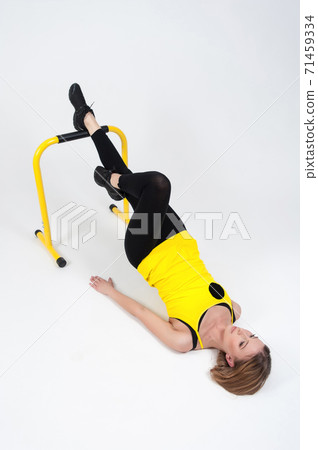 Woman doing exercises with high yellow floor bars on a white background Woman doing exercises with high yellow floor bars on a white background 71459334