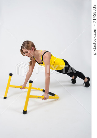 Woman doing exercises with high yellow floor bars on a white background Woman doing exercises with high yellow floor bars on a white background 71459338