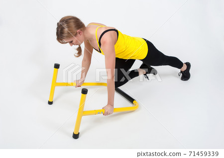 Woman doing exercises with high yellow floor bars on a white background Woman doing exercises with high yellow floor bars on a white background 71459339