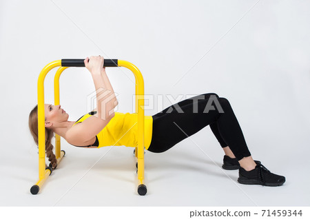 Woman doing exercises with high yellow floor bars on a white background Woman doing exercises with high yellow floor bars on a white background 71459344
