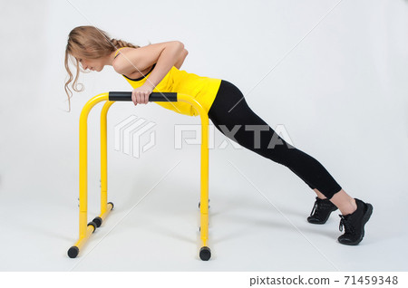 Woman doing exercises with high yellow floor bars on a white background 71459348