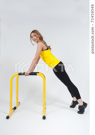 Woman doing exercises with high yellow floor bars on a white background 71459349