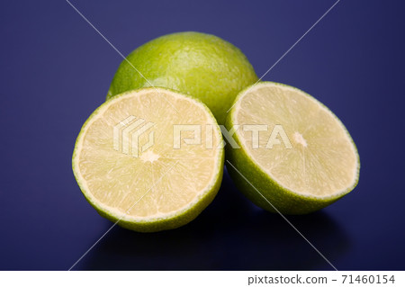 Cut citrus fruit of green lemon on blue background Cut citrus fruit of green lemon on blue background 71460154