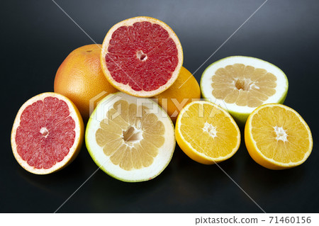 cut pieces of different citrus fruits on dark background cut pieces of different citrus fruits on dark background 71460156