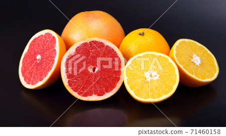 cut pieces of different citrus fruits on dark background cut pieces of different citrus fruits on dark background 71460158