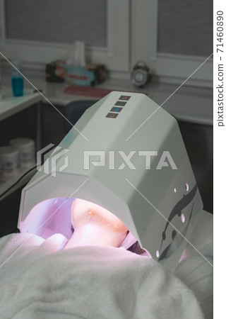 Patient under special light healing lamp Patient under special light healing lamp 71460890