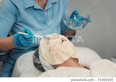 Therapist in a blua gloves and medical robe making Therapist in a blua gloves and medical robe making 71460895