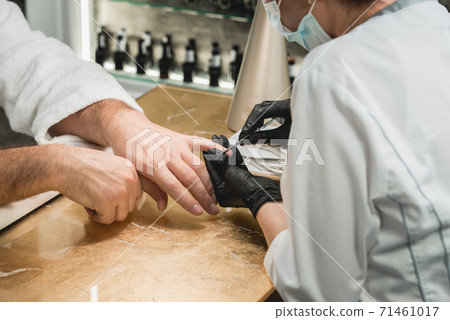 mans manicure master during nail treatment 71461017