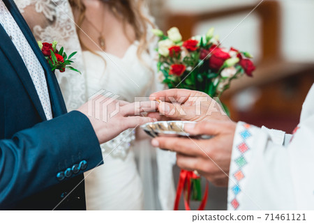 exchanging wedding rings. priest putting on golden 71461121