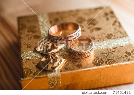 Pair of wedding golden rings on the golden gift 71461451