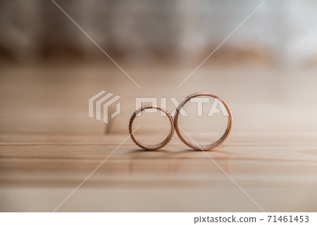 Pair of wedding golden rings on the yellow wooden Pair of wedding golden rings on the yellow wooden 71461453