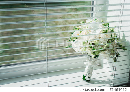 wedding bouquet of white roses on a window sill 71461612