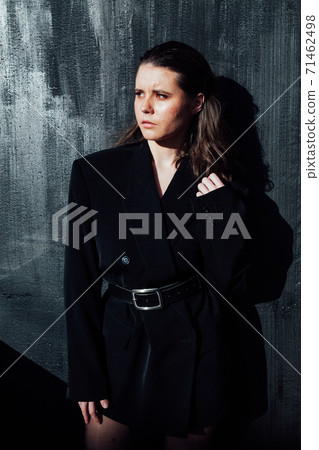 Portrait of a beautiful fashionable brunette woman in a black men's jacket Portrait of a beautiful fashionable brunette woman in a black men's jacket 71462498
