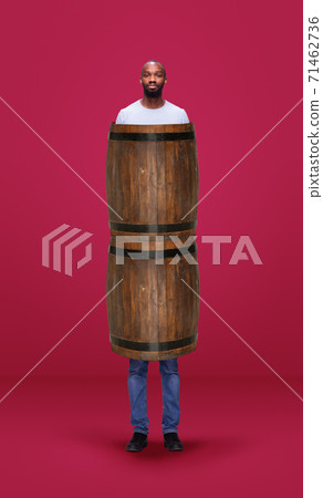 Tall high man and long barrel isolated on pink studio background. Unusual delighted and long Tall high man and long barrel isolated on pink studio background. Unusual delighted and long 71462736