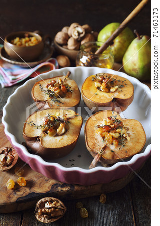Baked pears with raisins, walnuts and honey Baked pears with raisins, walnuts and honey 71463173